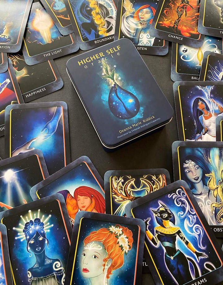 The Higher Self Oracle by Schiffer Publishing, Ltd. is spread out on a black surface, showing vibrant illustrations and words like Change, Balance, and Boundaries from this spiritual guidance oracle deck.