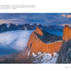 Experience the vibrant Colors of the Earth with Schiffer Publishing, Ltd.’s "The Colors of the Earth," featuring panoramic views of rugged mountain peaks in sunlight, snow patches, drifting clouds, and distant ranges under a blue sky.