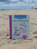 The “Under the Sea Besties” paper craft coloring book by Schiffer Publishing, Ltd. stands on a sandy beach with the ocean and people in the background. The cover shows cute aquatic characters and the subtitle "Color & Punch Fun.