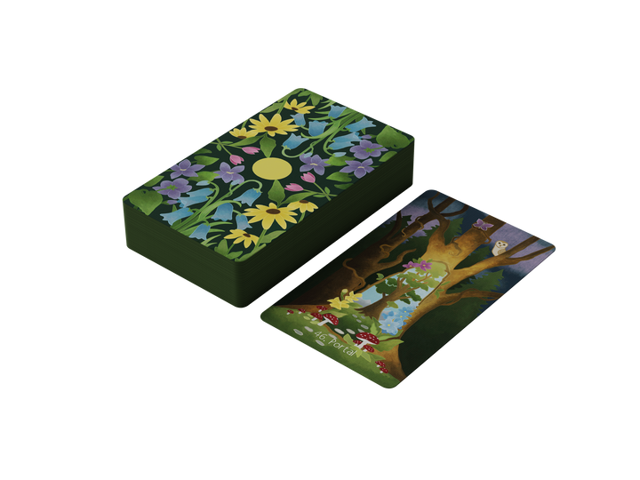 A stack of The Liminal Woods Oracle cards by Schiffer Publishing, Ltd. features floral backs; one card is face up, displaying a tree, snake, and mushrooms on dark green with "The Portal" title.