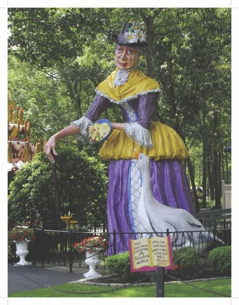 A statue of a woman holding a plate of food stands at Story Book Land, featured in "The Story of Story Book Land" from Schiffer Publishing, Ltd., celebrating the cherished amusement park near Atlantic City.