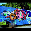 Truck Art by Schiffer Publishing, Ltd. showcases a blue-based trailer adorned with vibrant graffiti of bold shapes and letters in pink, orange, green, and blue, parked outdoors near trees and gravel.