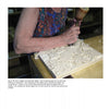 In Schiffer Publishing, Ltd.'s "Relief Carving with Nora Hall," intricate ornamental patterns are carved into wood using a mallet and chisel, demonstrating expert relief carving techniques with flowing designs.