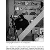 A man in a beanie sits on basement stairs, setting up a video camera among shelves and boxes, as if preparing to document Lehigh Valley ghosts for "Haunted Lehigh Valley" by Schiffer Publishing, Ltd.