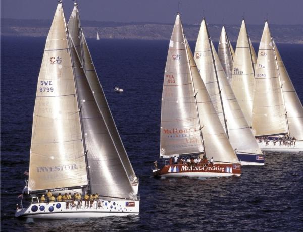 The book "Sailing Fascination" by Schiffer Publishing, Ltd. captures a stunning scene of sailing ships with tall white sails and yellow-clad crews racing closely on a calm blue sea, with a distant shoreline in the background.