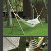 The Mind & Hand hammock by Schiffer Publishing, Ltd. hangs between four wooden poles on grass near trees and a brick building; close-ups of its rope knots emphasize details appealing to interior designers and handmade furniture lovers.