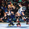 Three modern roller derby players in helmets and pads clash and fall on a rink during intense action in "No Mercy" by Schiffer Publishing, Ltd., as a crowd watches this thrilling contact sport.