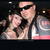 A tattooed and pierced couple poses closely for a bold portrait, showcasing the striking body modification style featured in "Ink & Steel" by Schiffer Publishing, Ltd.