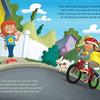 A girl in a pink dress smiles by a white fence as a boy rides a red bike, following safety rules from Schiffer Publishing, Ltd.'s "Bicycling Rules of the Road." A dog runs beside them; a yellow house and green hill appear in the background.