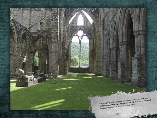 Sunlight streams through tall, arched windows of a stone abbey ruin, casting shadows on grassy floors—evoking scenes from Haunted Britain by Schiffer Publishing, Ltd., with green hills and trees visible under a clear sky.