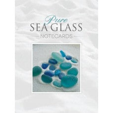Pure Sea Glass Notecards, Series 1 by Schiffer Publishing features artful photography of blue and green sea glass on soft white sand, creating a tranquil beach scene—perfect to pair with a keepsake box.