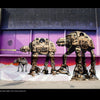 Exterior street art mural of three large AT-AT walkers as boomboxes in front of a purple-pink backdrop, inspired by UK graffiti writers and featured in "100 UK Graffiti Artists" from Schiffer Publishing, Ltd.
