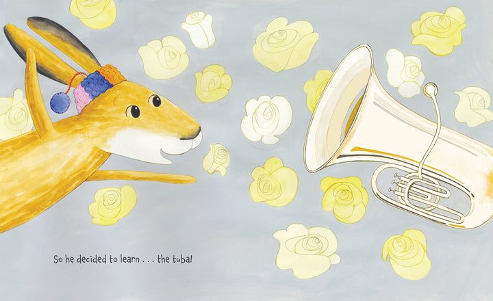 A cheerful rabbit in a colorful hat excitedly eyes a shiny tuba amid yellow roses on gray, blending music and nature. Text below says, So he decided to learn...the tuba! Product: The Tree in My Tuba by Schiffer Publishing, Ltd.