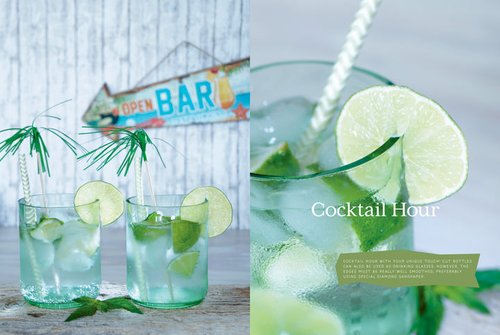 Two glasses of a lime and mint cocktail rest on wood, one with a palm leaf and lime slice. An OPEN BAR sign in the background inspires glass bottle crafts. Text reads “Cocktail Hour.” Product: Artfully Transforming Bottles & Plates by Schiffer Publishing, Ltd.