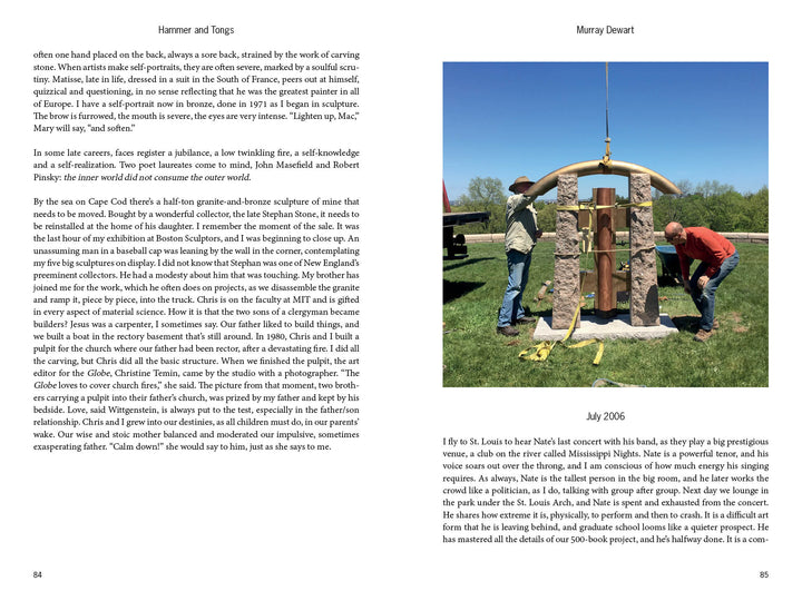 Two men assemble "Hammer and Tongs" by Schiffer Publishing, Ltd. outdoors using a yellow gantry crane. Upright stones emphasize the impact of public sculpture amidst grass, trees, and blue sky.